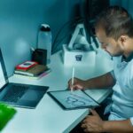 Graphic designer sketching a website layout on a tablet while transitioning into web design.